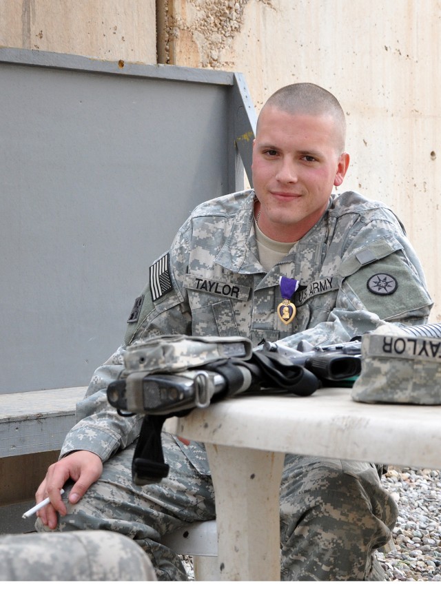 Staff Sgt. Justin Taylor, a Lancaster, Pa., native and assistant platoon sergeant for the 733rd Trans. Co., 395th CSSB stationed in Reading, Pa., wears his newly awarded purple heart while telling war stories to his comrades here, Dec. 17. (U.S....
