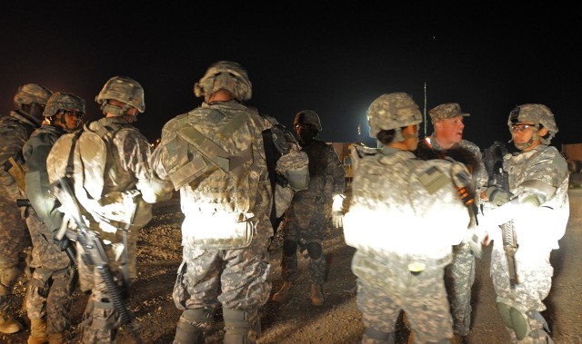 Soldiers of the 40th and 1174th Trans. Companies prepare to conduct pre-combat checks and pre-combat inspections before going on a convoy mission here Dec. 28 to turn in excess equipment at Contingency Operating Location Speicher. (U.S. Army photo by...