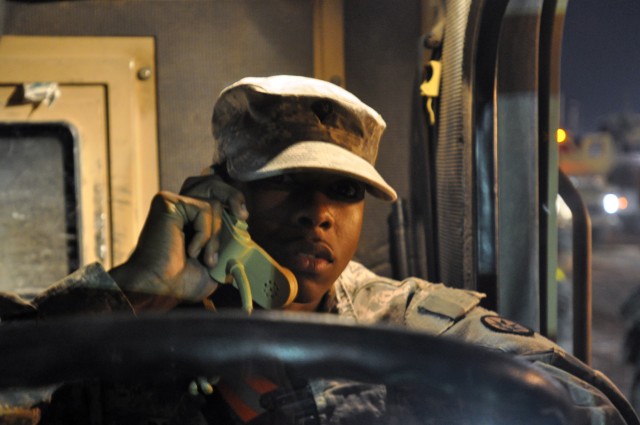 Spc. Pasquel Davis, a Roanoka, Va., native and communications specialist for 40th Trans. Co., conducts radio checks for trucks preparing to go on a convoy mission here Dec. 28 to turn in excess equipment at Contingency Operating Location Speicher. (U...