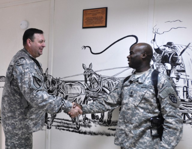 Col. Larry Phelps, the commander of the 15th Sustainment Brigade, shakes hands with Command Sgt. Maj. Nathaniel Bartee Sr., the 15th Sust. Bde.'s senior noncommissioned officer, at the newly dedicated McKay educational center Dec. 31 at...
