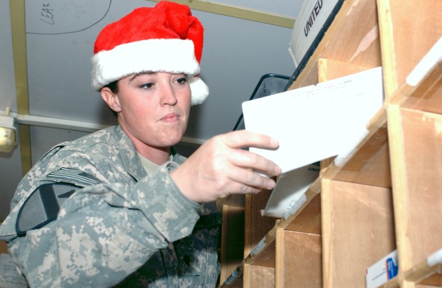 BAGHDAD - Spc. Krystal Juarez, a mail clerk assigned to Company A, Division Special Troops Battalion, 1st Cavalry Division, sorts letters during the holiday rush in the division mail room on Camp Liberty, Dec. 23. According to Juarez, daily mail has ...