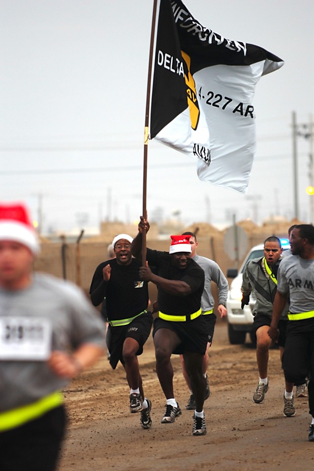 CAMP TAJI, Iraq - Soldiers from Company D, 4th Battalion, 227th Aviation Regiment, 1st Air Cavalry Brigade, 1st Cavalry Division, charge the finish line at the end of the 5K Jingle Bell Run hosted by 4-227th, here, Dec. 25. Although the run was to...