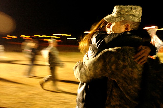 Sgt. 1st Class Jennifer Edwards, of Co. A, 15th Brigade Support Battalion, 2nd Brigade Combat Team, 1st Cavalry Division, kisses her husband, Sgt. 1st Class Jerald Edwards, of 2nd BCT Headquarters, as he and more than 100 others returned Dec. 26, fro...