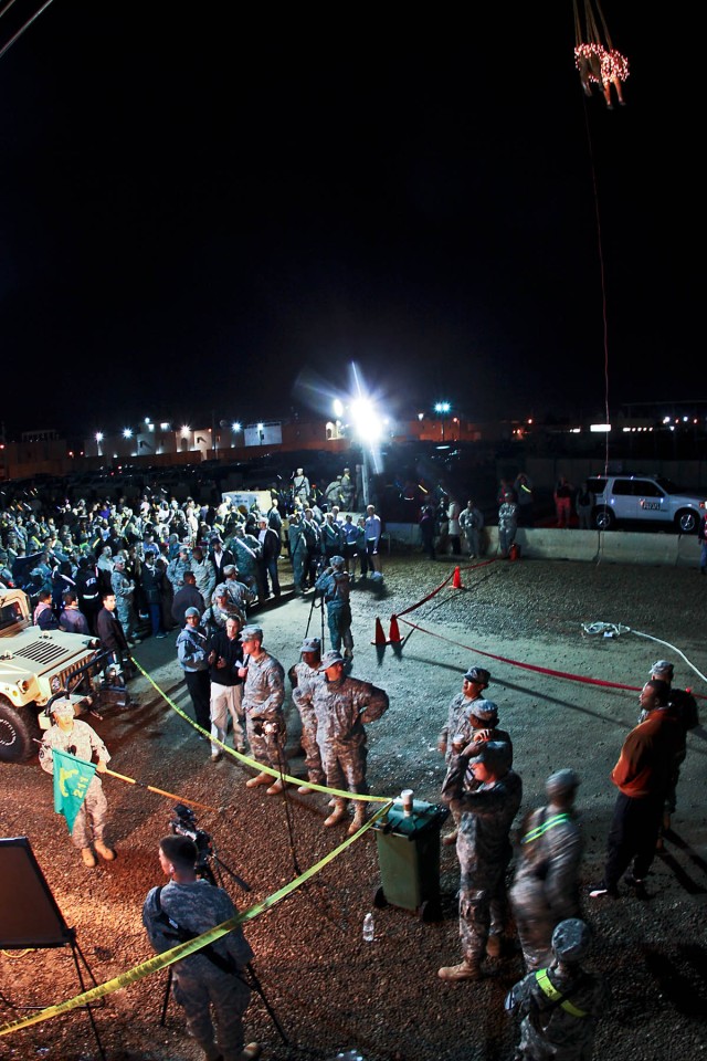 CAMP TAJI, Iraq - As the last minutes of 2009 tick away, Soldiers gathered into the street to watch a fake camel covered in Christmas lights drop to bring in the New Year, here, Dec. 31. The camel drop and talent show was organized by the 115th...