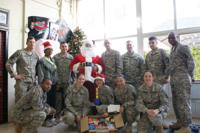 The battalion staff takes a group photo with Santa. Top row from left to right: Lt. Col. Steven Debusk, Sgt. Brittany Brim, 1st Lt. Genaro Morones, Pvt. Edward Shaw, Maj. John Kredo, Capt. Myron Johnson, 1st Lt. Vladimir Carrillo, and Capt. John...