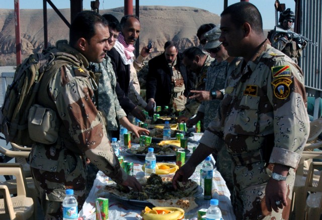 CONTINGENCY OPERATING LOCATION Q-WEST, Iraq - Mississippi Guardsmen share a feast of curried rice and lamb with senior leaders of the Iraqi Army's 26th Brigade on the lift station dock of the Al Qayyarah pump house, Dec. 29. The Mississippians...