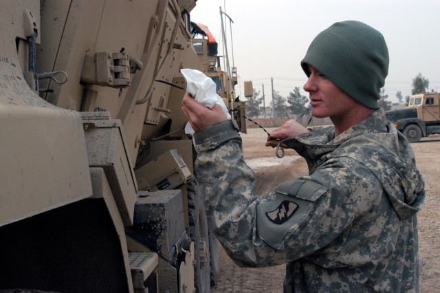 CONTINGENCY OPERATING LOCATION Q-WEST, Iraq - Spec. Richard M. Webb, a driver from Pickens, Miss., checks the oil of his Mine-Resistant, Ambush-Protected gun truck during a during a quality assurance / quality control inspection in the company...