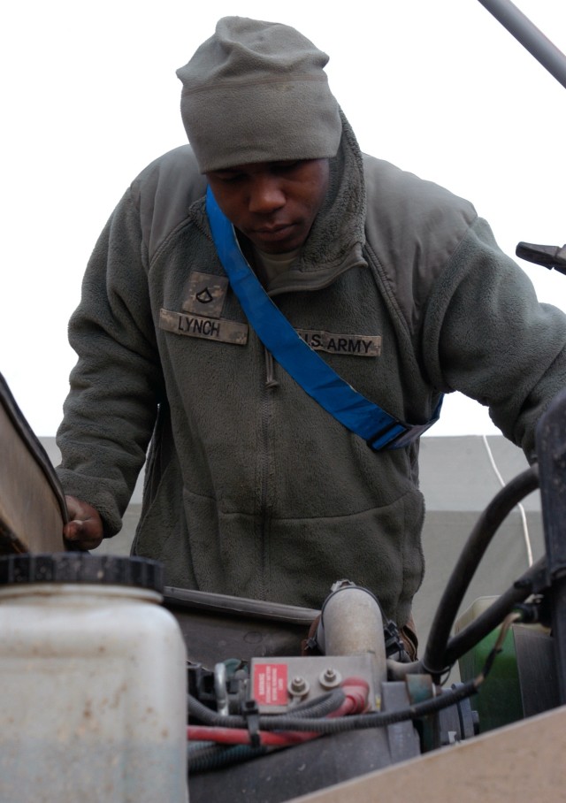 CONTINGENCY OPERATING LOCATION Q-WEST, Iraq - Pfc. Ivory D. Lynch, a mechanic from Oxford, Miss., checks a gun truck motor for deficiencies during a quality assurance / quality control inspection in the company motor pool Jan. 5. Lynch serves with...