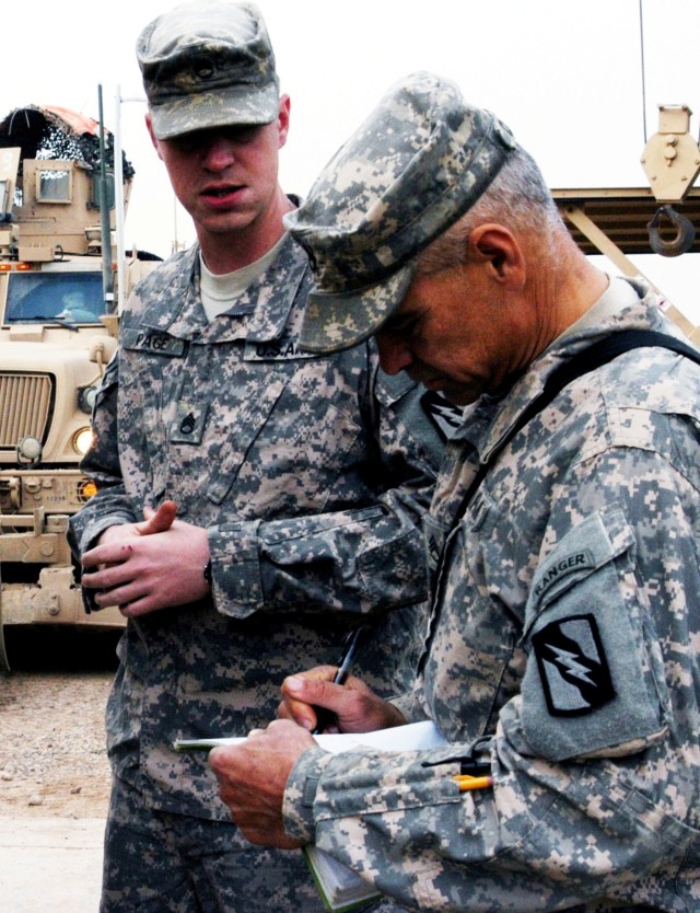 CONTINGENCY OPERATING LOCATION Q-WEST, Iraq - Staff Sgt. Wesley N. Page (left), a gun truck commander from Starkville, Miss., consults with Staff Sgt. David W. Cantrell, a convoy commander from Madison, Miss., during a quality assurance / quality...