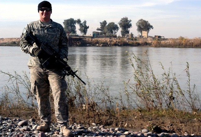 CONTINGENCY OPERATING LOCATION Q-WEST, Iraq - Cpl. Terry B. Nolan, a gunner from Horn Lake, Miss., stands on the bank of the Tigris River during a security mission to the Al-Qayyarah pump house Dec. 29. Nolan serves with A Company, 2nd Battalion,...