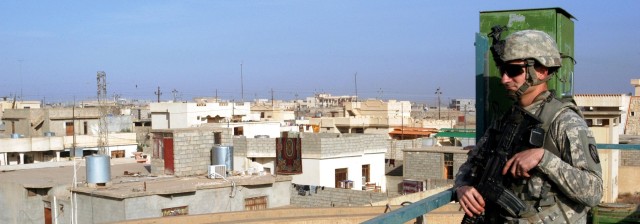 CONTINGENCY OPERATING LOCATION Q-WEST, Iraq - Staff Sgt. Jonathan C. Love, a squad leader from Southaven, Miss., scans the rooftops of Al-Qayyarah during a visit to the filtration plant pumping water to Contingency Operating Location Q-West, Dec....
