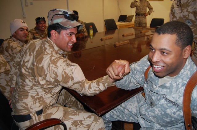 CAMP TAJI, Iraq -Staff Sgt. Darian Ford, a human intelligence collection team leader assigned to Company A, 1st Brigade Special Troops Battalion, 1st Brigade Combat Team, 1st Cavalry Division, arm wrestles a soldier from Field Engineering...