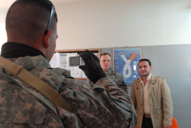 JSS ISTIQLAAL, Iraq - Birmingham, Ala. native, Sgt. Charles Ray (left), an intelligence support team representative for Troop A, 1st Squadron, 7th Cavalry Regiment, 1st Brigade Combat Team, 1st Cavalry Division, photographs the head doctor at a local...