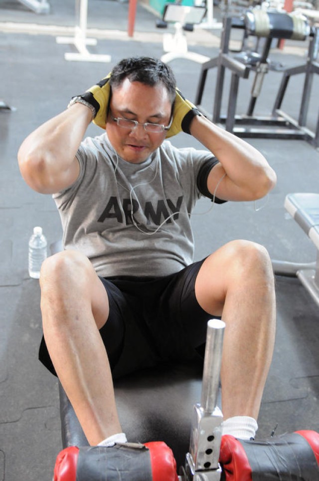 BAGHDAD - Staff Sgt. Roongpetch Kaewnork, a food service sergeant assigned to Company B, Division Special Troops Battalion, 1st Armored Division, United States Division-Center, performs inverted sit-ups at the division's gym, Jan. 10. The Hampton, Va...