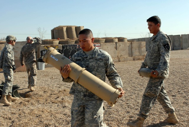 CAMP TAJI, Iraq - Little Rock, Ark. native Capt. Alex Aquino, commander for Battery B, 1st Battalion, 82nd Field Artillery Regiment, 1st Brigade Combat Team, 1st Cavalry Division, carries a 155mm round to an M777 howitzer in preparation for a live fi...
