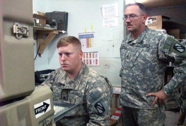 CONTINGENCY OPERATING LOCATION Q-WEST, Iraq - Staff Sgt. Kevin L. Brown (sitting), a sergeant of the guard from Hernando, Miss., and Sgt. Russell R. Rippy, an assistant sergeant of the guard from Nashville, Tenn., monitor the video output of surveill...
