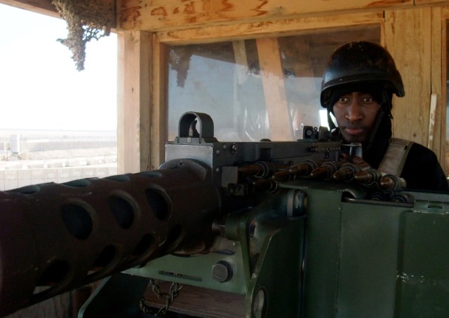CONTINGENCY OPERATING LOCATION Q-WEST, Iraq - Mercy Arimaitwe, a civilian security contractor from Mbarara, Uganda, mans a .50 cal. machine gun during entry control point operations at Contingency Operating Location Q-West, Jan. 10. Arimaitwe is supe...
