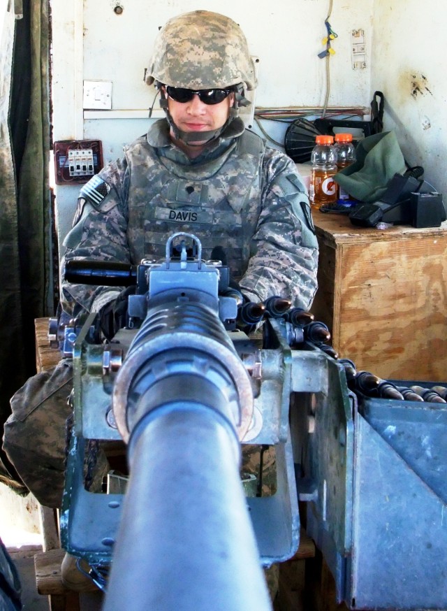 CONTINGENCY OPERATING LOCATION Q-WEST, Iraq - Spc. Calvin L. Davis, a native of Red Banks, Miss., mans a .50 cal. machine gun in a tower at the main entry control point of Contingency Operating Location Q-West, Jan. 10. Davis serves with A Company, 2...
