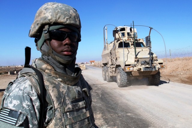 CONTINGENCY OPERATING LOCATION Q-WEST, Iraq - Pfc. Quintavis B. Byrd, a gate sentinel from Tutwiler, Miss., watches gun trucks pass the main entry control point of Contingency Operating Location Q-West, Jan. 10. Byrd serves with A Company, 2nd Battal...