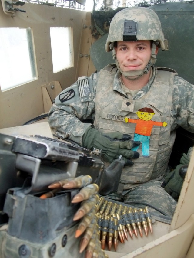 CONTINGENCY OPERATING LOCATION Q-WEST, Iraq - Spc. Philip A. Pigford, a gunner from Memphis, Tenn., poses in at Contingency Operating Location Q-West Jan. 13 with "Flat Stanley," a paper doll used in a pen-pal program. Third-graders with Cheryl Hays'...