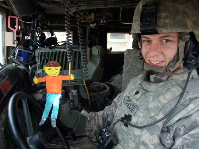 CONTINGENCY OPERATING LOCATION Q-WEST, Iraq - Spc. Lorence K. Strange, a gun truck driver from New Albany, Miss., poses in at Contingency Operating Location Q-West Jan. 13 with "Flat Stanley," a paper doll used in a pen-pal program. Third-graders wit...