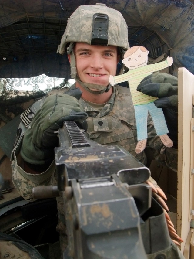 CONTINGENCY OPERATING LOCATION Q-WEST, Iraq - Spc. Daniel S. Moore, a gunner from Horn Lake, Miss., poses in at Contingency Operating Location Q-West Jan. 13 with "Flat Stanley," a paper doll used in a pen-pal program. Third-graders with Cheryl Hays'...