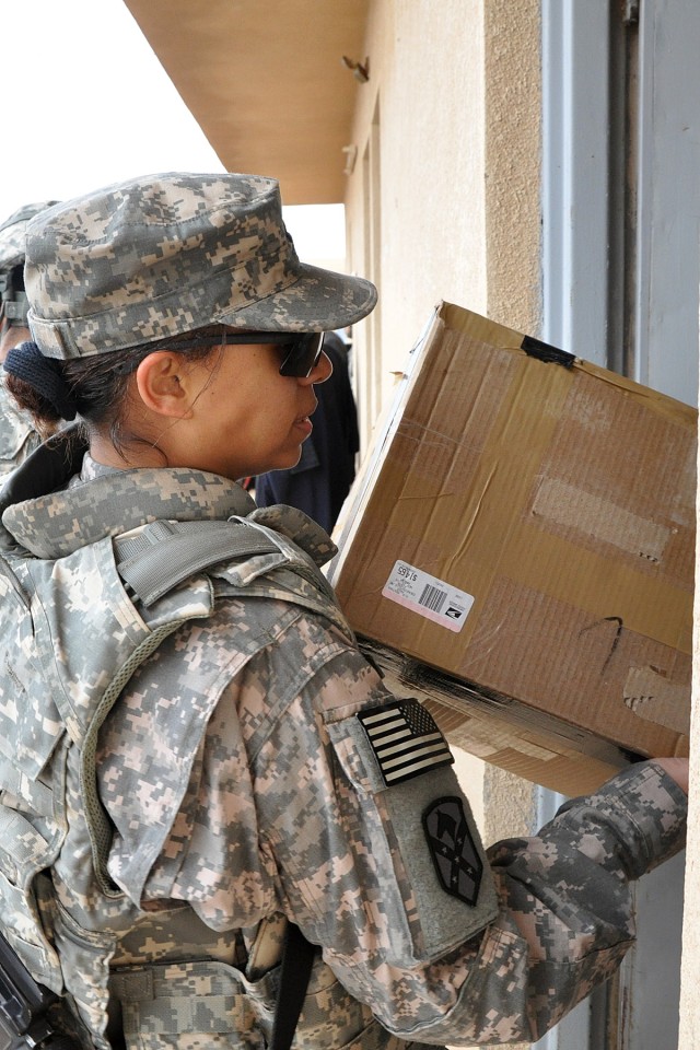 Capt. Elaina Hill, the 15th Sustainment Brigade adjutant, carries a box of school supplies into the school Jan. 20 in the Iraqi village of Jedellah Sofla, near Contingency Operating Location Q-West, Iraq. During the visit, members of the brigade...