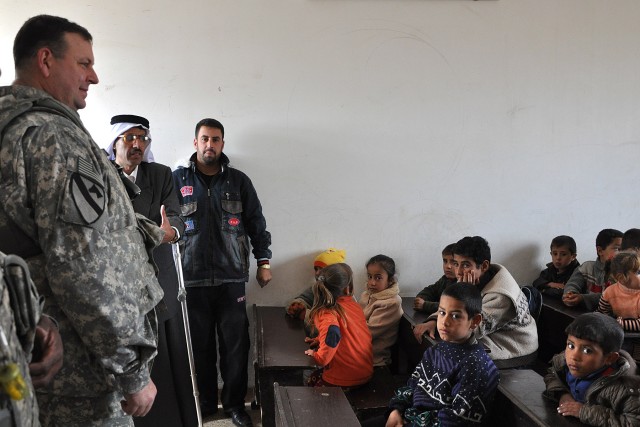 Iraqi students listen to Col. Larry Phelps, the commander of the 15th Sustainment Brigade, during a Jan. 20 visit to their school in Jedellah Sofla, a village near Contingency Operating Location Q-West. (U.S. Army photo by Staff Sgt. Rob Strain,...
