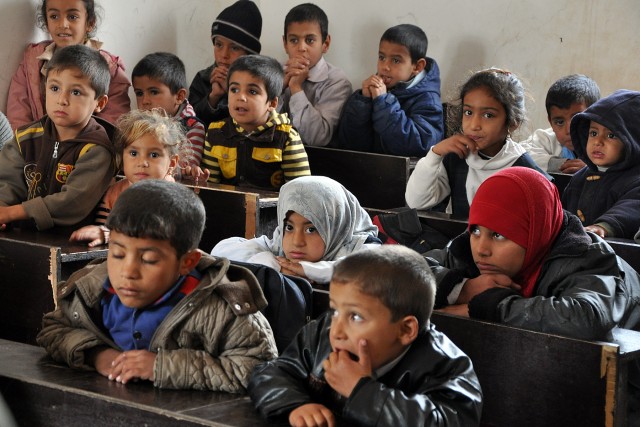 Iraqi students listen to Col. Larry Phelps, the commander of the 15th Sustainment Brigade, during a Jan. 20 visit to their school in Jedellah Sofla, a village near Contingency Operating Location Q-West. (U.S. Army photo by Staff Sgt. Rob Strain,...