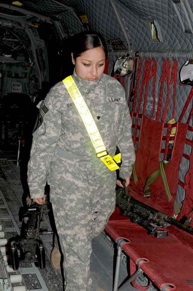 BAGHDAD - While carrying two 240B machine guns, Spc. Bernice Garcia, a Houston native and Chinook door gunner with Company B, 3rd Battalion, 227th Aviation Regiment, 1st Aviation Cavalry Brigade, 1st Cavalry Division, finally exits the Chinook after ...