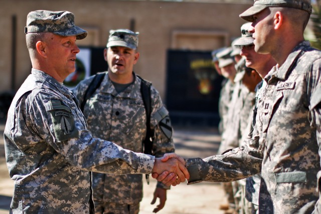 CAMP TAJI, Iraq - During a visit to 1st Air Cavalry Brigade Jan. 27, Brig. Gen. Kevin Mangum (left), deputy commanding general of 1st Armored Division, USD - C, from Newport News, Va., shakes hands with Capt. David Puzzo, from East Hampton, Conn.,...