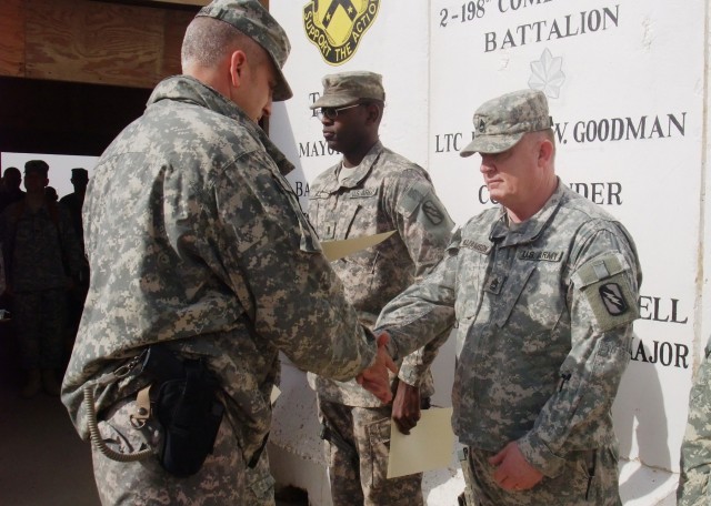 CONTINGENCY OPERATING LOCATION Q-WEST, Iraq - Lt. Col. Kerry Goodman, a Meridian, Miss., resident and commander of 2nd Battalion, 198th Combined Arms, out of Senatobia, Miss., presents a certificate of recognition to Sgt. 1st Class Joseph A....