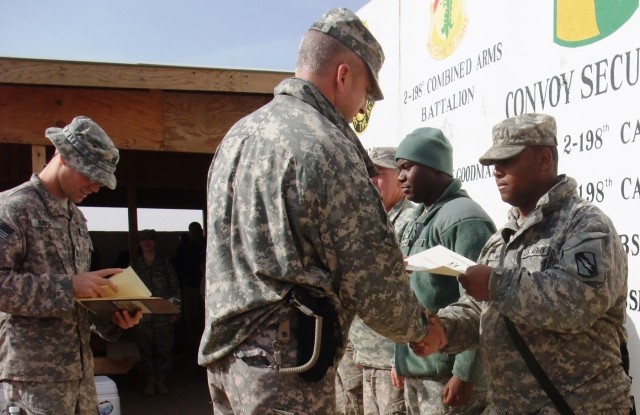 CONTINGENCY OPERATING LOCATION Q-WEST, Iraq - Capt. Robert P. Sayle (left), a battalion safety officer and native of Lake Cormorant, Miss., reads a certificate of recognition as Lt. Col. Kerry Goodman, a Meridian, Miss., resident and commander of...
