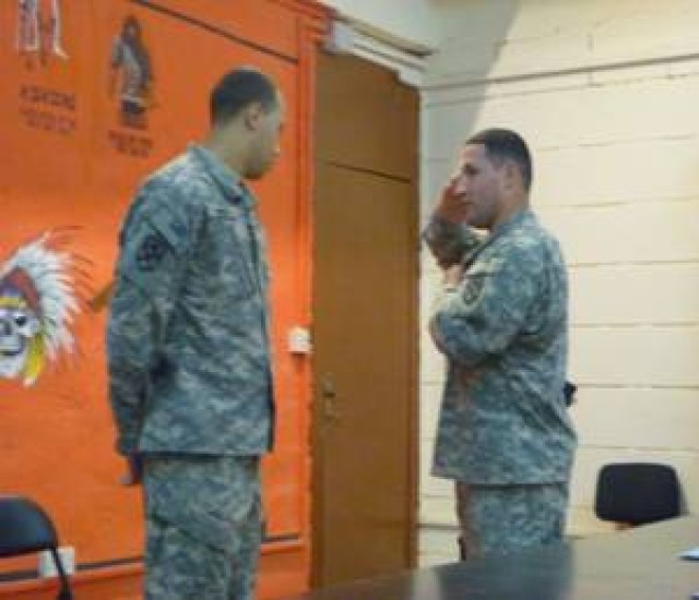 Sgt. Irving Newberry (right), a Washington native and an A Co., 15th STB, 15th Sust. Bde. multi-channel transmission system operator-maintainer, helps show one of his Soldiers the finer points of saluting while at the position of sling arms. (U.S....