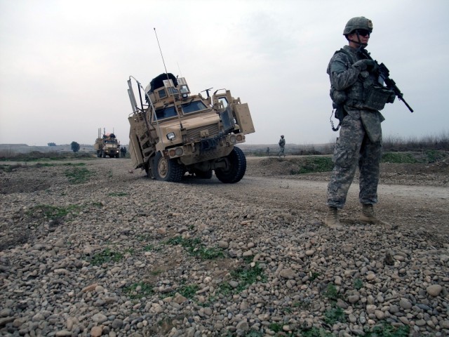 CONTINGENCY OPERATING LOCATION Q-WEST, Iraq - Spc. Tommy J. Thomason Jr., a gunner from Holliday, Texas, stands security while awaiting Q-West's vehicle recovery quick reaction force to arrive and extract a Mine-Resistant, Ambush-Protected gun...