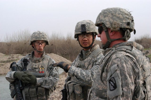 CONTINGENCY OPERATING LOCATION Q-WEST, Iraq - Staff Sgt. William S. Zakrzewski (left), a squad leader from Leesville, La., and 1st Lt. Neng P. Vang (middle), a platoon leader from Sacramento, Calif., consult with Staff Sgt. Douglas S. Kilgore, a...