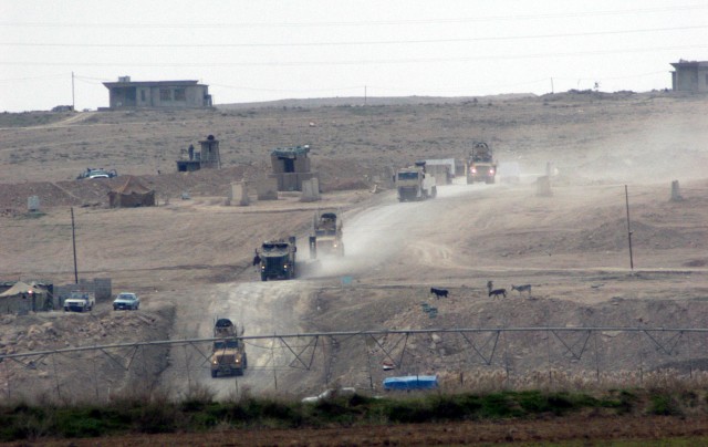 CONTINGENCY OPERATING LOCATION Q-WEST, Iraq - Gun trucks of the Q-West quick reaction force for recovering vehicles descend a valley in Ninewa Province, where they will help recover a combat vehicle stuck in a sinkhole, Jan. 18. The recovery QRF -...