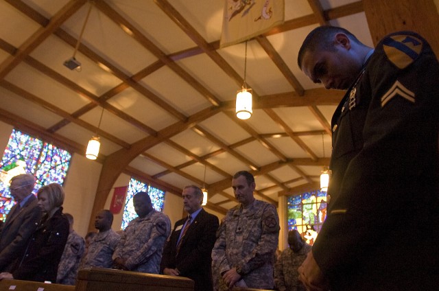 Cpl. David Haig, a team leader with the 1st Brigade Combat Team, 1st Cavalry Division lowers his head for prayer during a memorial service for two fallen Cavalry Soldiers, Sgt. David Andrew Croft, and Pvt. Jhanner Andres Tello, who were...