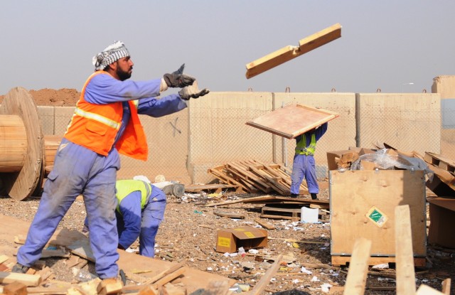 An Iraqi worker, contracted by the United Mandour Company, loads wood onto a truck Feb. 1 at the recycling yard at Joint Base Balad, Iraq. The pallets will be resold or reused in nearby villages. The jobs and supplies help boost the local economy and...