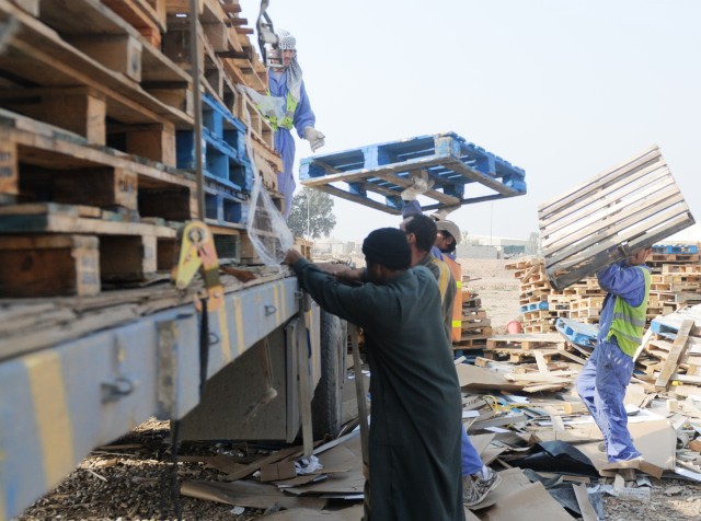 Iraqi workers, contracted by the United Mandour Company, load pallets onto a truck Feb. 1 at the recycling yard at Joint Base Balad, Iraq. The pallets will be resold or reused in nearby villages. The jobs and supplies help boost the local economy and...