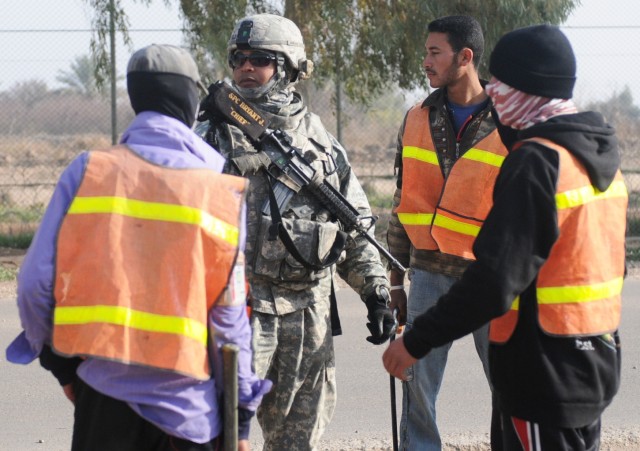 Spc. Julian H. Bryant, an escort with the 547th Transportation Company, 49th Transportation Battalion, 15th Sustainment Brigade, 13th Sustainment Command (Expeditionary), escorts Iraqis on details around Joint Base Balad, Iraq. Bryant, a Landover,...
