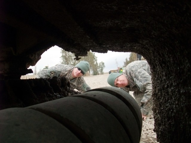 CONTINGENCY OPERATING LOCATION Q-WEST, Iraq - Sgt. Edwin L. Pauley (left), a scout truck commander from Salisbury, Md., and Spc. Michael A. Boucher, a scout truck driver from Batesville, Miss., examine the road mud caked beneath the mud flaps of...