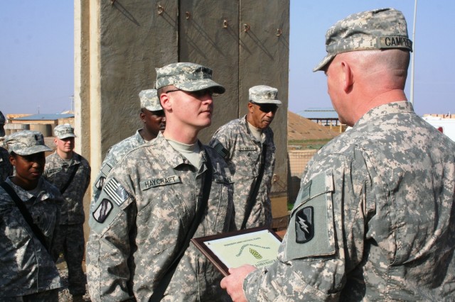 CONTINGENCY OPERATING LOCATION Q-WEST, Iraq - Sgt. James C. Haycraft (left) - the non-commissioned officer in charge of the Mayor Cell water operations off the post and combat medic from Brandon, Miss. - poses with Command Sgt. Maj. Perry...