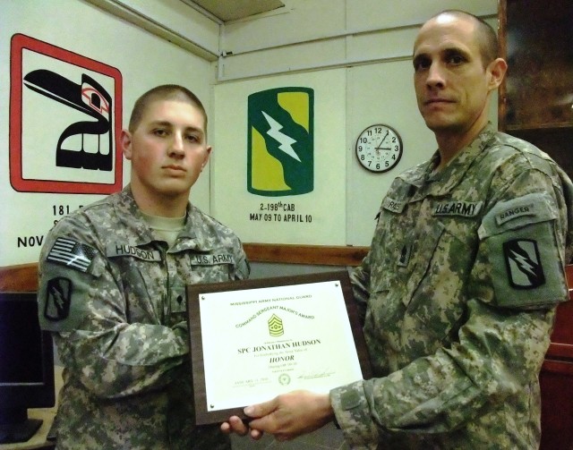 CONTINGENCY OPERATING LOCATION Q-WEST, Iraq - Spc. Jonathan C. Hudson (left), a gun truck commander from Batesville, Miss., receives a Command Sergeant Major's from Sgt. Maj. John T. Raines, a battalion operations sergeant major and resident of...