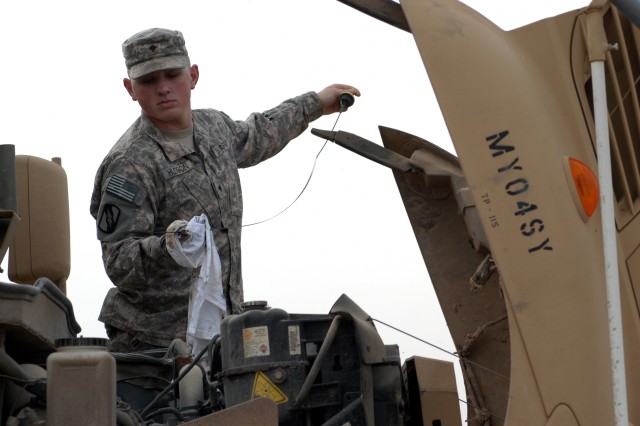 CONTINGENCY OPERATING LOCATION Q-WEST, Iraq - Spc. Jonathan C. Hudson, a gun truck commander from Batesville, Miss., checks the oil level of a Mine-Resistant, Ambush-Protected gun truck during preventative maintenance checks and services in the...