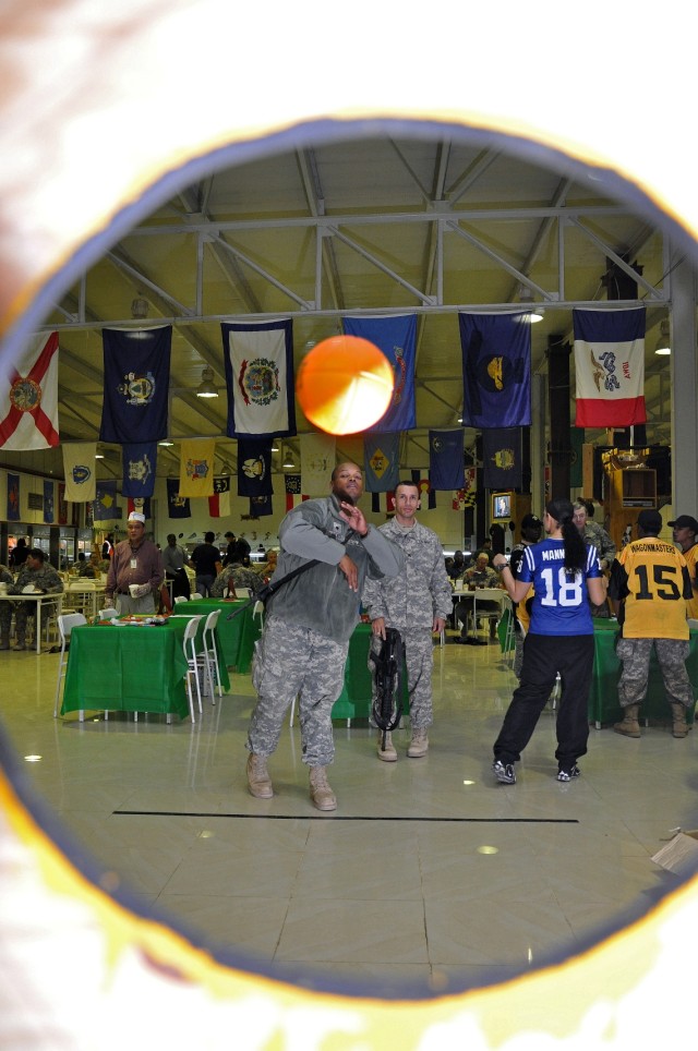 Spc. Jahari Reed, a petroleum supply specialist in Headquarters and Headquarters Company, 15th Special Troops Battalion, 15th Sustainment Brigade, 13th Sustainment Command (Expeditionary), throws a foam football towards a target hole in a game at...
