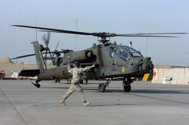 CAMP TAJI, Iraq-An AH-64D Apache attack helicopter is directed off the airfield Feb. 11 by Spc. Douglas Davis, from Fountain City, Ind., an Apache crew chief for Company C, 1st Battalion, 227th Aviation Regiment, 1st Air Cavalry Brigade, 1st Cavalry ...