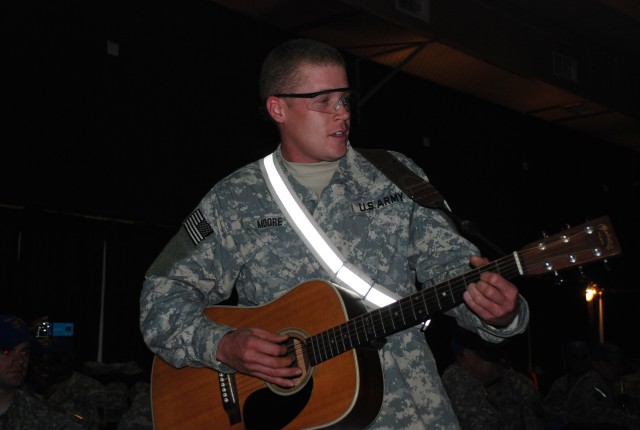 Cpl. Joshua Moore of Gilbert, Ariz., a track vehicle mechanic assigned to the 3666 Support Maintenance Company, 541st Combat Sustainment Support Battalion, 15th Sustainment Brigade, 13th Sustainment Command (Expeditionary), sings and plays his...