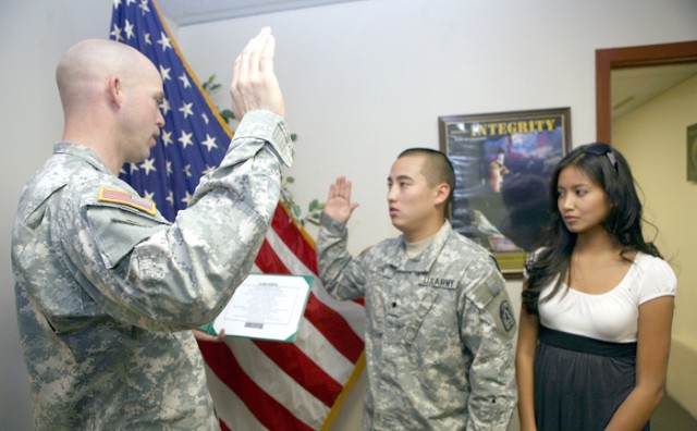 Retention3 - LT. Dan Harris (Left), Charlie Company 86 BSB, reads the oath of reenlistment and swears in SPC Brian Kon, Charlie Company 86 Signal Battalion with his wife Rhra by his side at the Post Retention office bldg, 41414 on post 4 February. Ko...