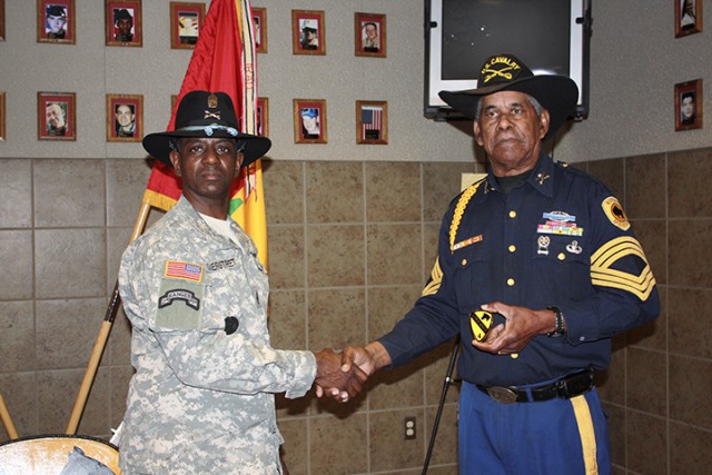 Command Sgt. Major Antoine Overstreet, 4th Brigade Combat Team, 1st Cavalry Division, gives retired Sgt. Major James Williams a 4th BCT coin during a Buffalo Soldier presentation at the Operation Iraqi Freedom Memorial Dining Facility Feb. 19. ...